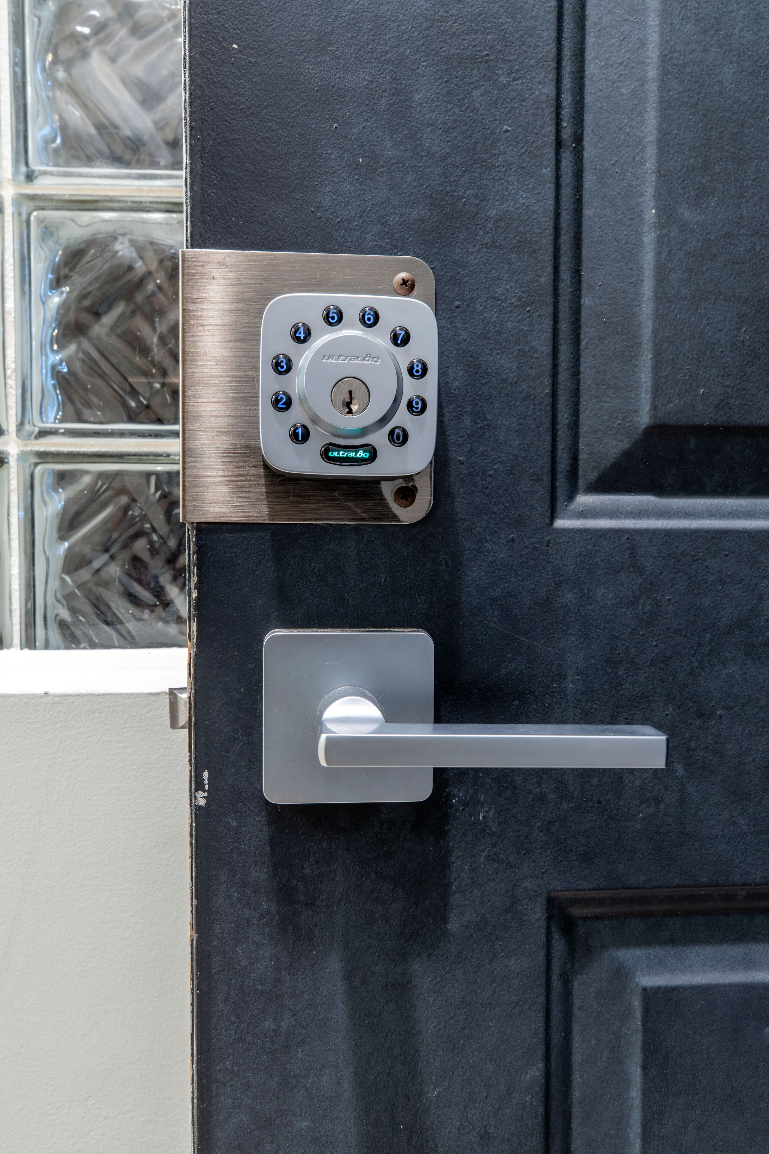A door with a keypad lock and a door handle.