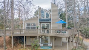 A two-story house with a deck, a covered patio, and a staircase.