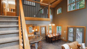 Una vivienda de varios niveles con escalera, comedor y cocina.
