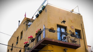 Un edificio de varios pisos con balcones, algunos con jardineras.