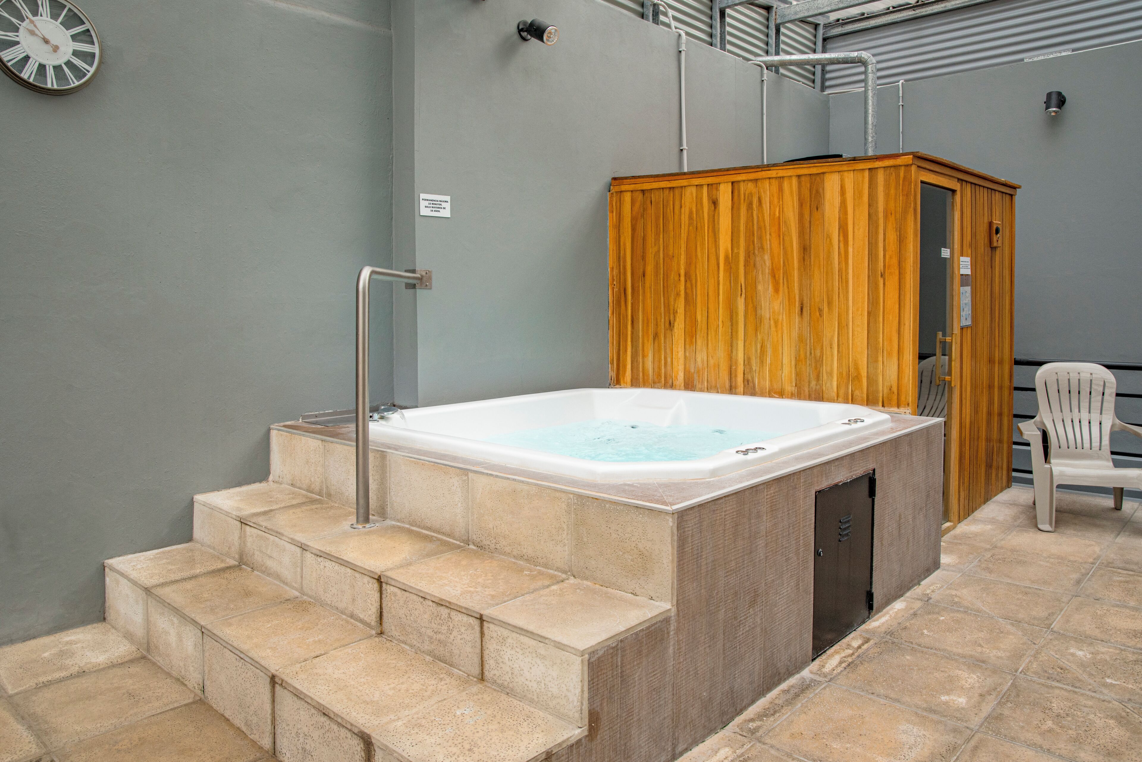 Una piscina techada, sillones reclinables de piscina