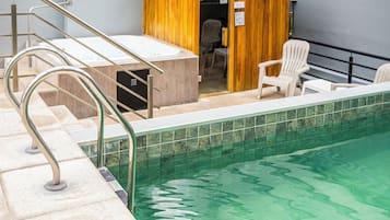 Una piscina techada, sillones reclinables de piscina