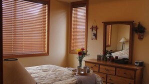 A bedroom with a bed, dresser, mirror, and a lamp. - Apex Mountain ~ Moose Lodge (Apex Mountain Resort)