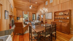 A wooden interior with a dining area, kitchen, and living room. - 3BR Chachalaca Retreat on Sapelo w/ firepit, screened-in porch, & beach supplies (Sapelo Island)