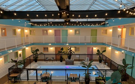 A multi-level atrium with a pool, seating areas, and potted plants.