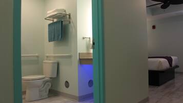 A bathroom with a toilet, towel rack, and a visible shower area.
