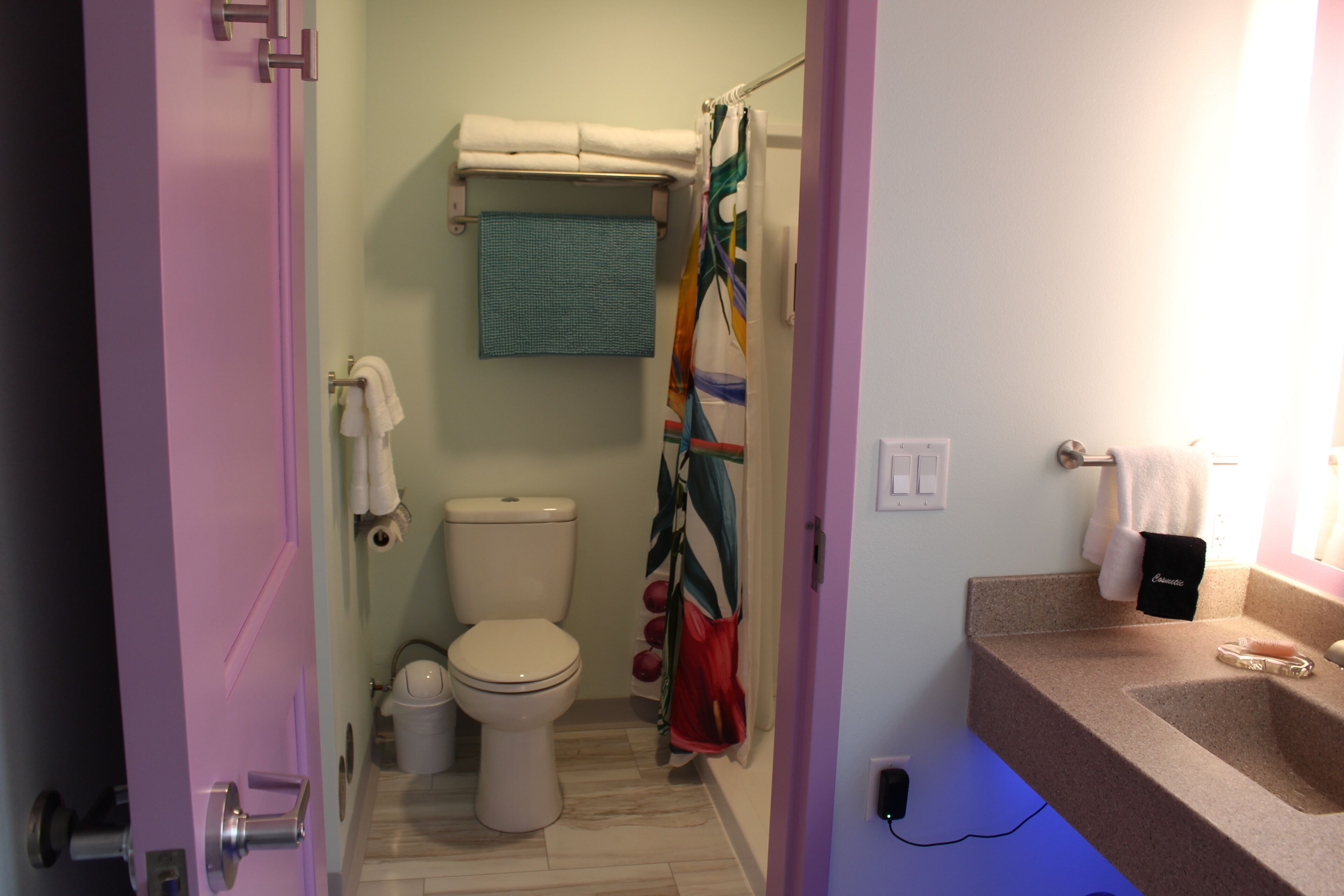 A bathroom with a toilet, sink, and shower curtain.