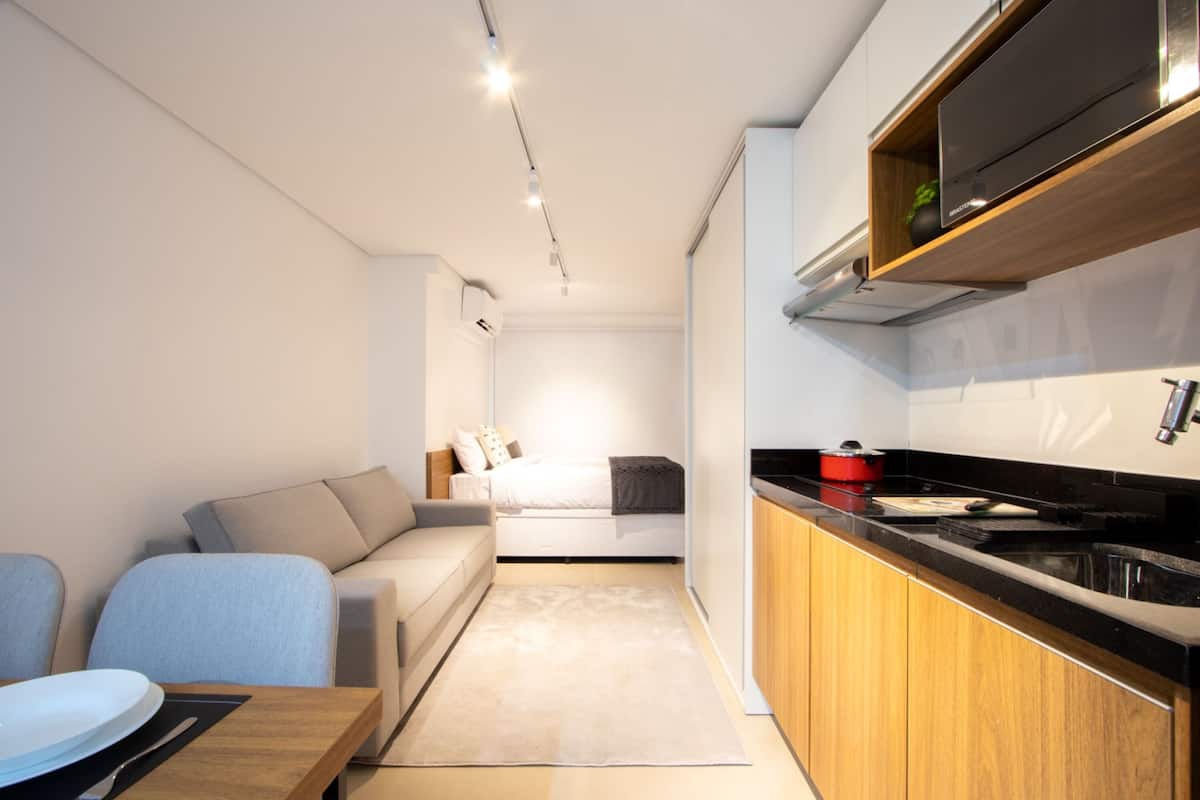Een knus verblijf met kitchenette, een bank, eettafel en een bed.