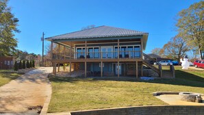 A two-story house with a deck, a small pool, and a stone wall. - Emma's View On Lay Lake<br>SUMMERTIME ON LAY LAKE IS THE BEST!!☀️ (Shelby)