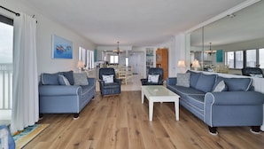Ein geräumiges Wohnzimmer mit zwei Sofas, einem Couchtisch und einem Essbereich im Hintergrund.