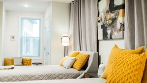 A hotel room with two beds, a nightstand, a lamp, and a window with curtains. - The Inn at Newton Highlands, boutique apartment-hotel (Newton)