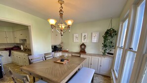 A dining area with a wooden table, cushioned benches, and a chandelier. - Hot Tub and Private Pool, 7 Bedroom, 4 Bathroom Home. Sleeps 16 comfortably. (Warrenton)