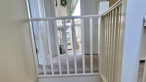 A staircase with a wooden handrail and carpeted steps leading to a second floor. - Hot Tub and Private Pool, 7 Bedroom, 4 Bathroom Home. Sleeps 16 comfortably. (Warrenton)