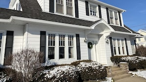 A two-story house with a gabled roof, white siding, and black shutters. - Hot Tub and Private Pool, 7 Bedroom, 4 Bathroom Home. Sleeps 16 comfortably. (Warrenton)