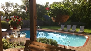 A wooden deck with a pool, lounge chairs, and a bench. - Hot Tub and Private Pool, 7 Bedroom, 4 Bathroom Home. Sleeps 16 comfortably. (Warrenton)