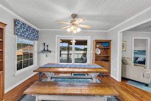 Relax in this inviting room with a balcony view, a comfortable sofa, and a wooden cabinet.
