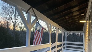A covered porch with white railings and a flag. - Bourbon Trail & Relaxing rural spot. Restored Farmhouse on 22 private acres. (Lawrenceburg)