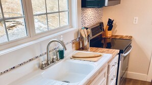 A kitchen with a white sink, stainless steel appliances, and a wooden countertop. - Bourbon Trail & Relaxing rural spot. Restored Farmhouse on 22 private acres. (Lawrenceburg)