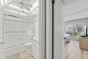 A modern bathroom with a shower, toilet, and vanity.