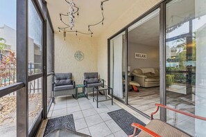 A balcony with seating, a glass door leading to a living area, and a sign reading 'RELAY.'