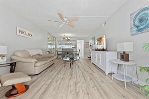 A modern living room with a sofa, coffee table, and a ceiling fan.