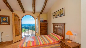 Une chambre à coucher avec un lit, une commode, une table de chevet, une lampe et un tableau.