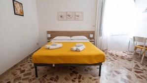 Habitación de hotel con una cama, una silla y una obra de arte en la pared.