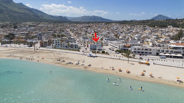 A coastal town with a beach, clear turquoise waters, and a mountainous backdrop. - Casa Blu, a house directly by the sea and in a central location in San Vito Lo Capo. (SAN VITO LO CAPO)