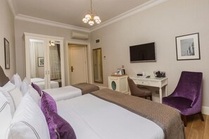 A hotel room with two beds, a desk, a chair, a TV, and a mirror. - Meroddi Galata Mansion (Istanbul)