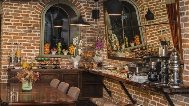 A restaurant with brick walls, a wooden bar counter, and a dining area with a table and chairs. - Meroddi Galata Mansion (Istanbul)