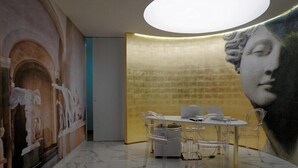 Un espace repas comprenant une table et des chaises, une fresque murale et un luminaire au plafond.