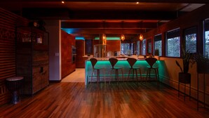 Une cuisine moderne avec un plancher en bois, un coin bar avec des tabourets et de grandes fenêtres.