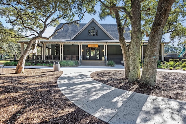 A building with a porch, a covered walkway, and a sign reading 'the nest.'