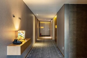 A hotel hallway with a reception desk, a lamp, and a fire extinguisher. - Paju Mate Hotel (Paju)