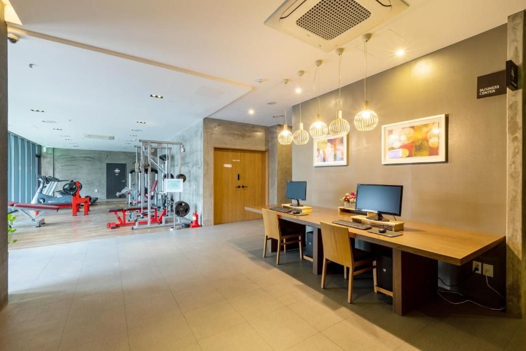 A modern office space with a desk, computer, and ergonomic chairs.