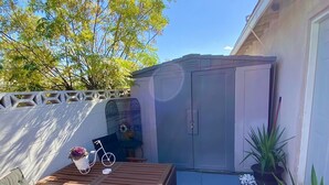 A patio area with a wooden table and chairs, a potted plant, and a white door. - Private Studio 4 minutes from Strip !!! (Las Vegas)