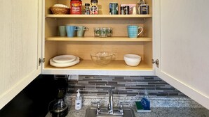 A kitchen with open cabinets, a stainless steel sink, and various kitchen items on shelves. - Private Studio 4 minutes from Strip !!! (Las Vegas)