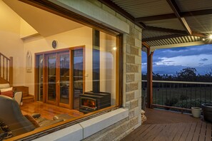 Una sala de estar acogedora con chimenea, puertas de cristal amplias y una terraza de madera.