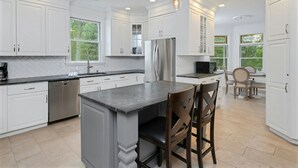 A modern kitchen with white cabinetry, a central island, and pendant lighting. - Private Luxury Stay in Expansive Home & Property (EASTON)