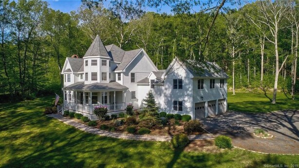 A large, two-story house with a wrap-around porch and a garage. - Private Luxury Stay in Expansive Home & Property (EASTON)