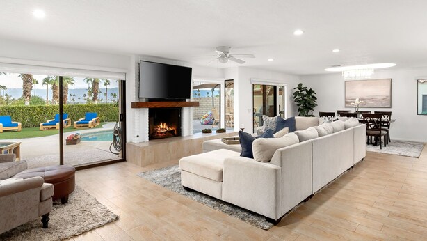 A spacious living room with a fireplace, a large sofa, and a television. - Everything you want! Pool/spa, Golf Course, Mountain Views (Palm Desert)