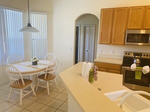 Enjoy cooking in this well-equipped kitchen with a central island, sink, and stainless steel oven.