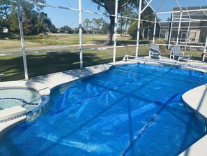 Relax by the pool surrounded by lush greenery and comfortable lounge chairs.