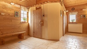 A wooden interior with a bench, a door, and a window with a plant.