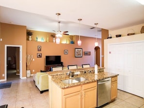 Enjoy cooking and relaxing in this well-equipped kitchen and living area with a central island, sink, and dishwasher.