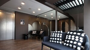 A modern interior with a sofa, chairs, and a mirror. - ST Signature Bugis Beach, DAYUSE, 8-9 hours: check in 8AM or 11AM (Singapore)