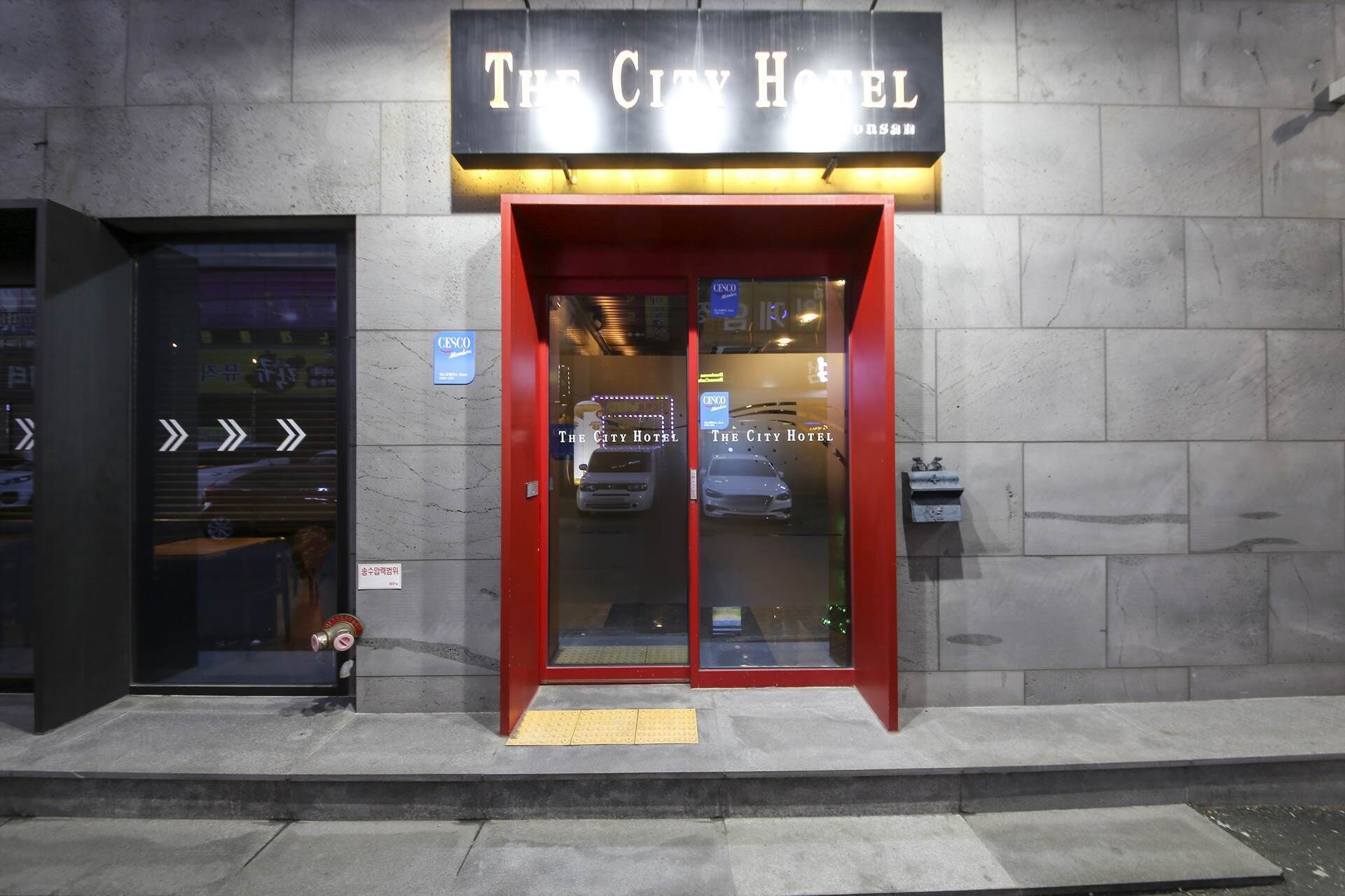 The exterior of The City Hotel with a prominent entrance and a visible CESCO sign.