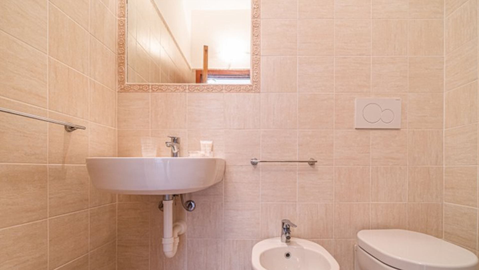 A bathroom with a sink, bidet, and toilet.