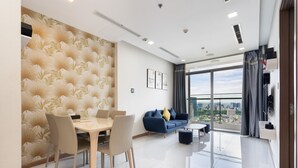 A modern living room with a dining area, a sofa, and a view of the city.