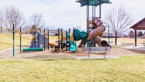 A playground with a slide, climbing structures, and a covered play area.